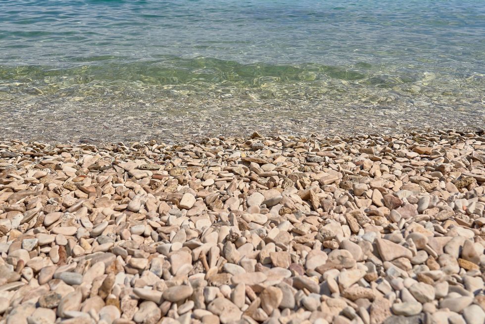 Rotsachtig strand bij Split met kristalhelder water
